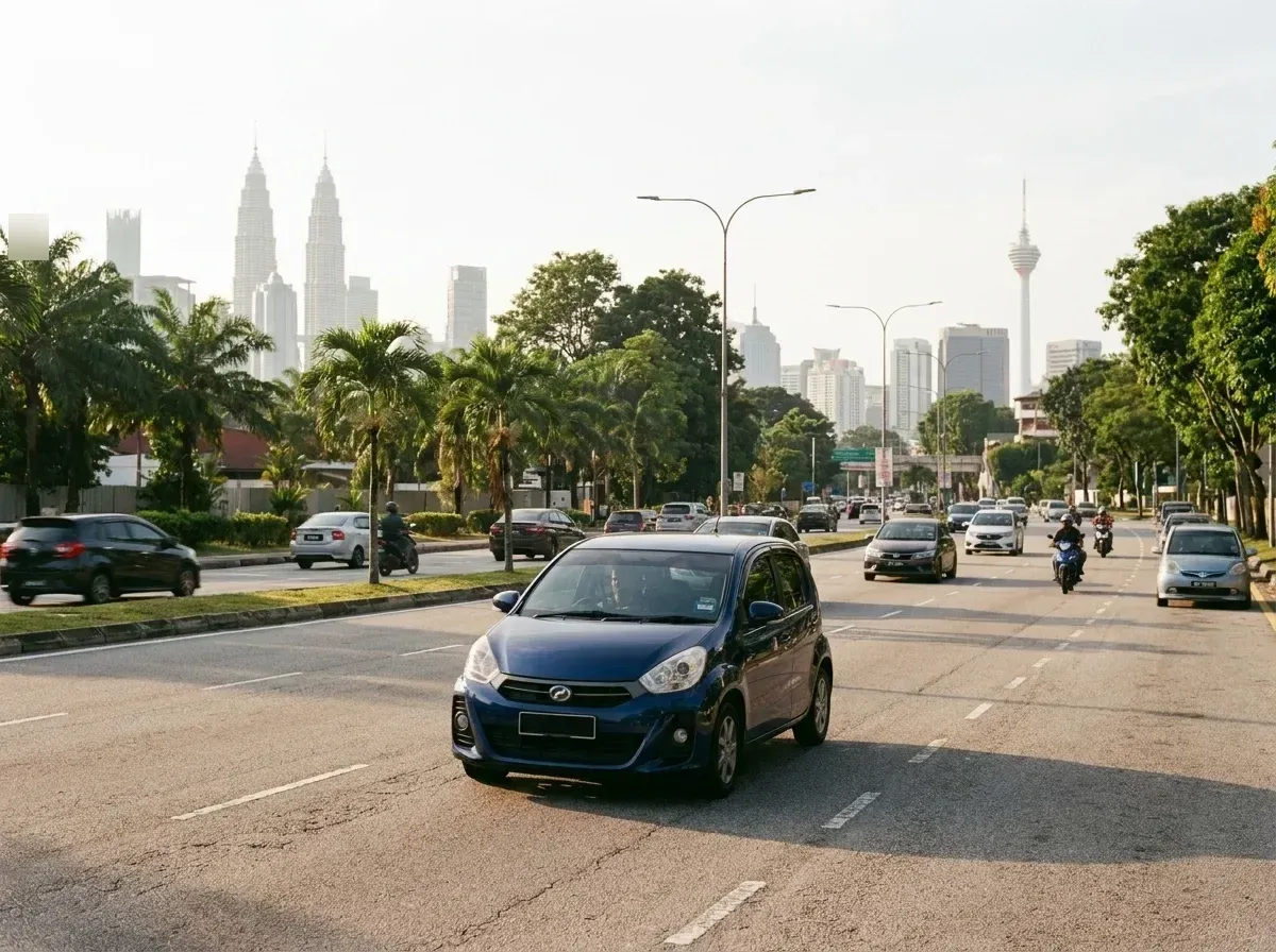 Kereta kompak melalui jalan raya Kuala Lumpur dengan latar langit bandar dan pohon palma