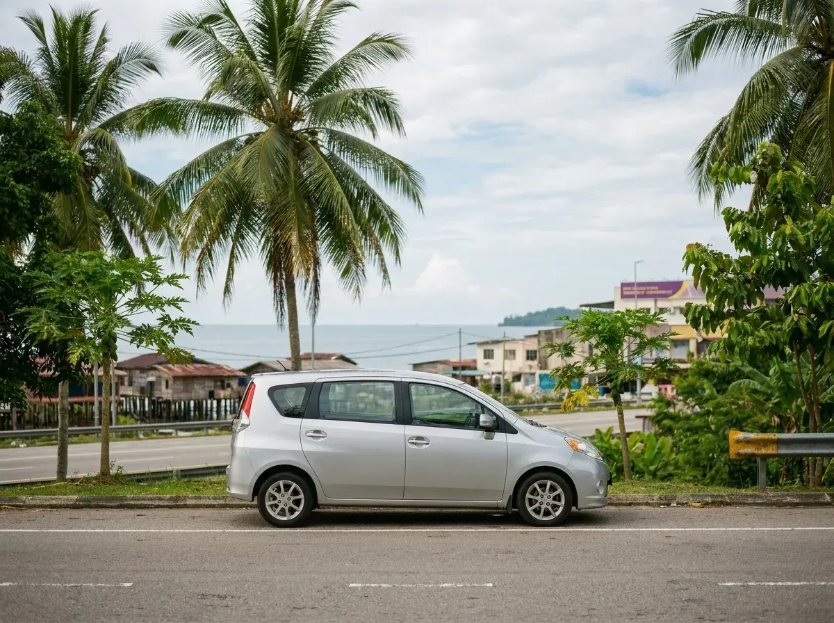 Kereta MPV perak di jalan pesisir Kota Kinabalu dengan pemandangan tropika