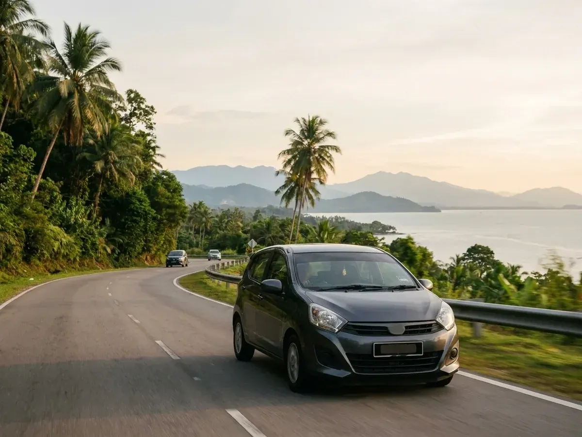 Kereta sewa tanpa jenama melalui jalan pantai Sabah dengan pemandangan gunung dan laut dalam cahaya petang.