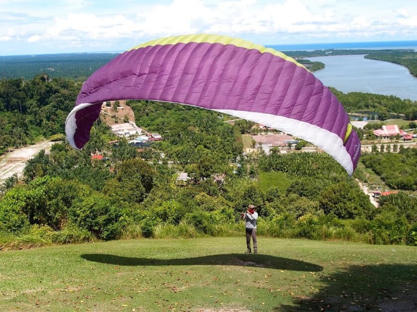 man getting ready for paragliding in tandem pedas paragliding park in negeri sembilan
