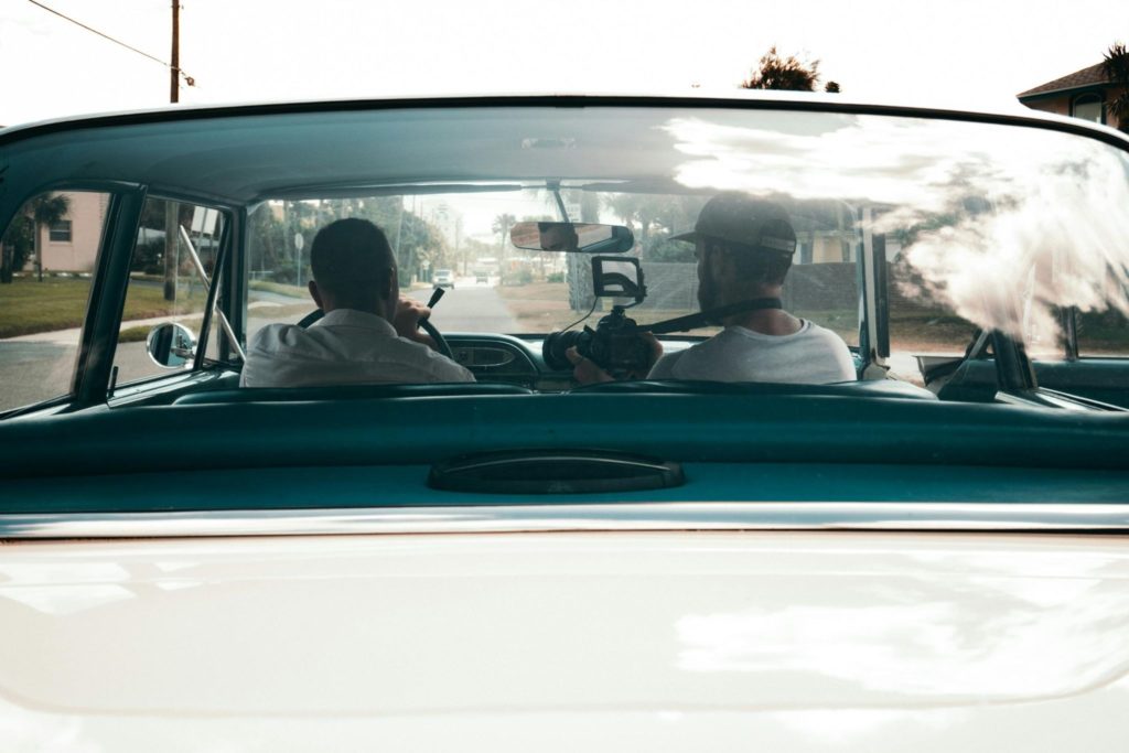 a man and his father in a rental car on a road trip to celebrate Father's Day